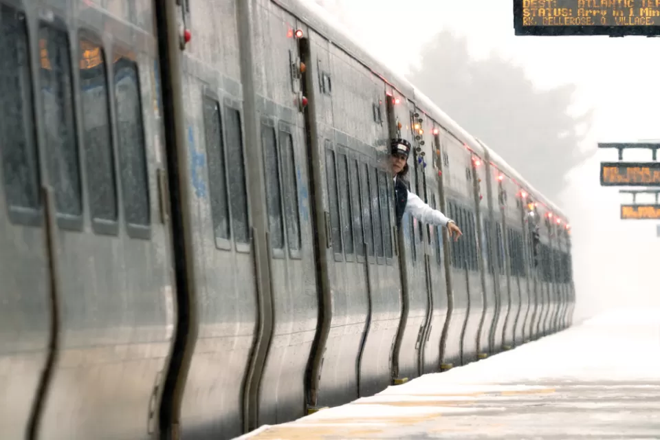 A train conductor waves at an empty platform on the Long island Rail Road system.